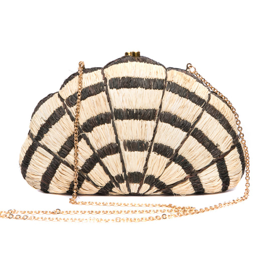 Seashell Karuna Clutch featuring hand-embroidered raffia fiber, freshwater pearls wrapped in brass, and a brass drop-in chain strap for versatility.
