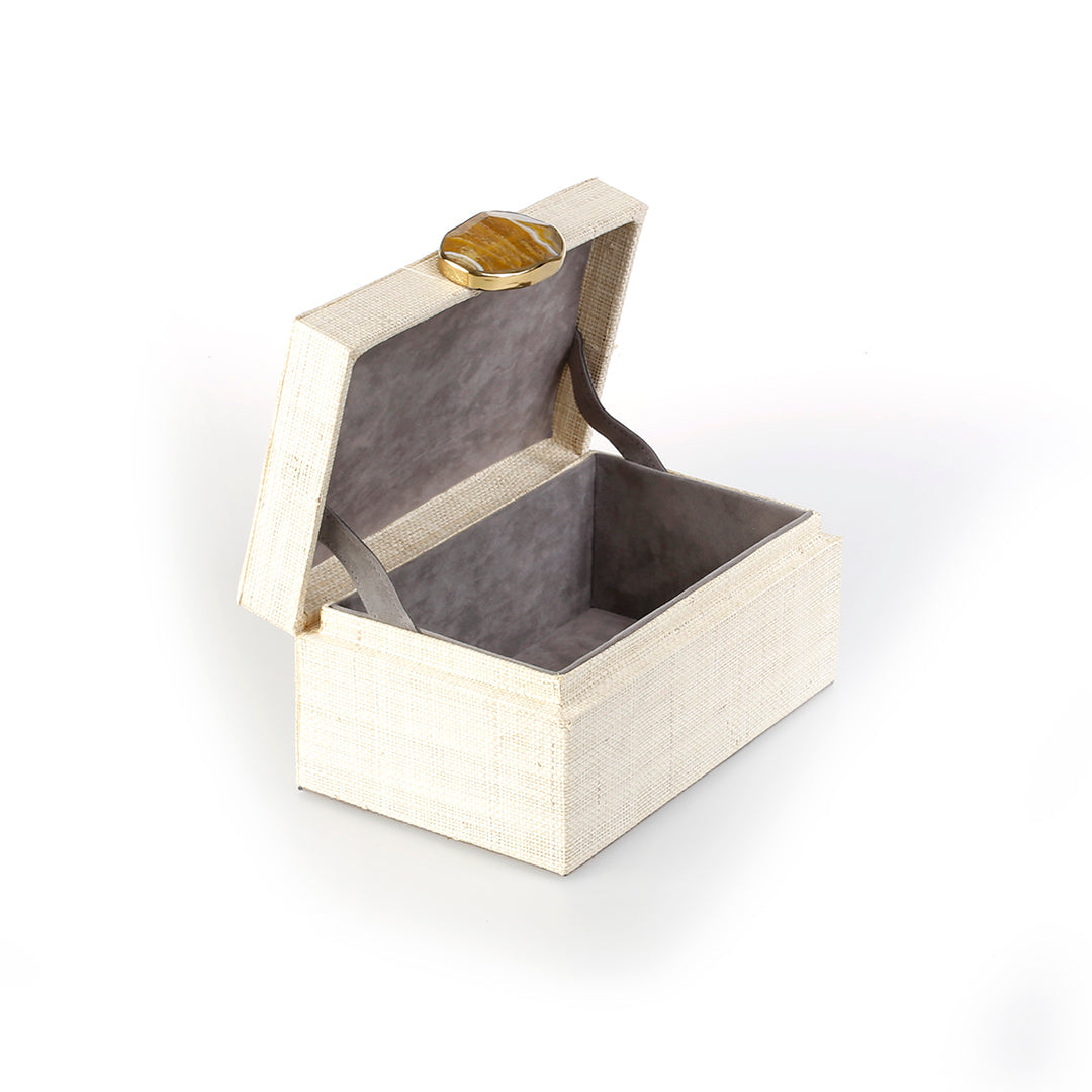 Karuna Raffia Jewelry Box, handcrafted from 100% natural raffia with a polished agate stone accent and hand-tooled brass detailing. Elegant, eco-friendly storage for jewelry and keepsakes.