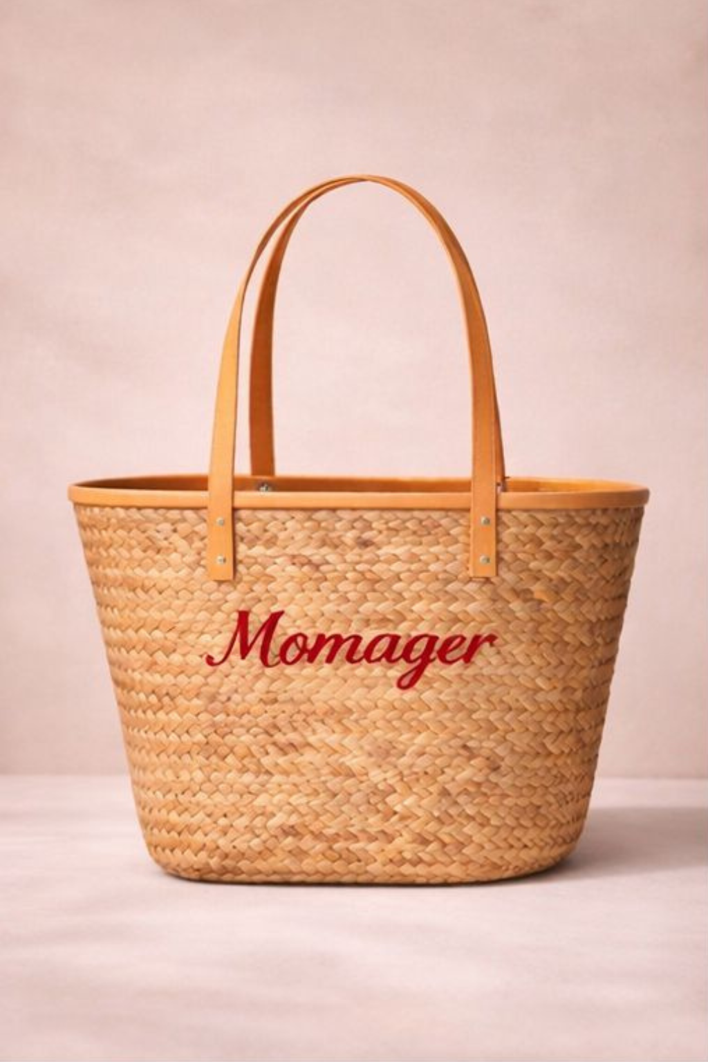 Woven bag with 'Momager' embroidery on a beige background