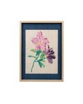 Front view of hand-embroidered pink and purple floral wall art with a navy blue mat and light wood frame.