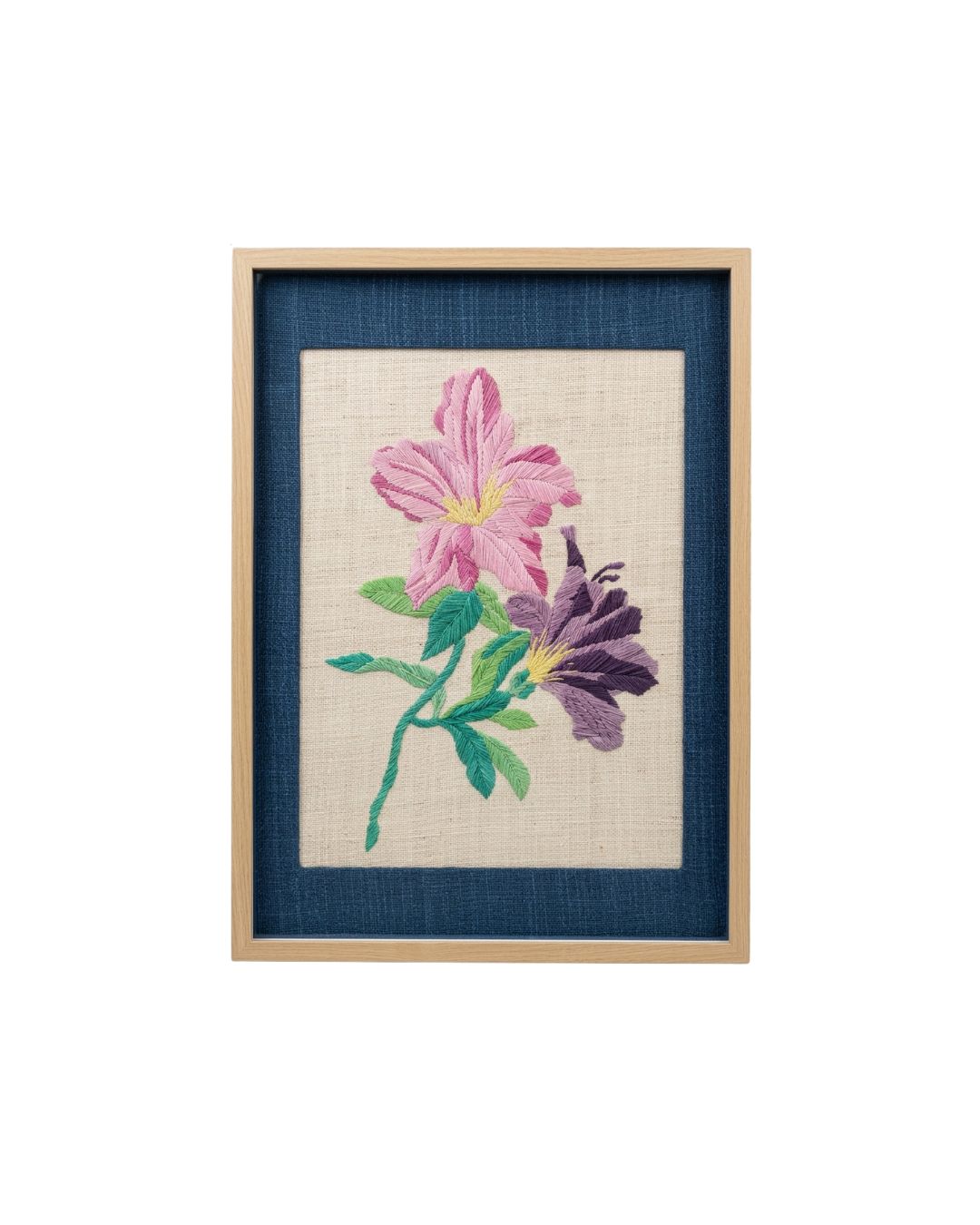 Front view of hand-embroidered pink and purple floral wall art with a navy blue mat and light wood frame.