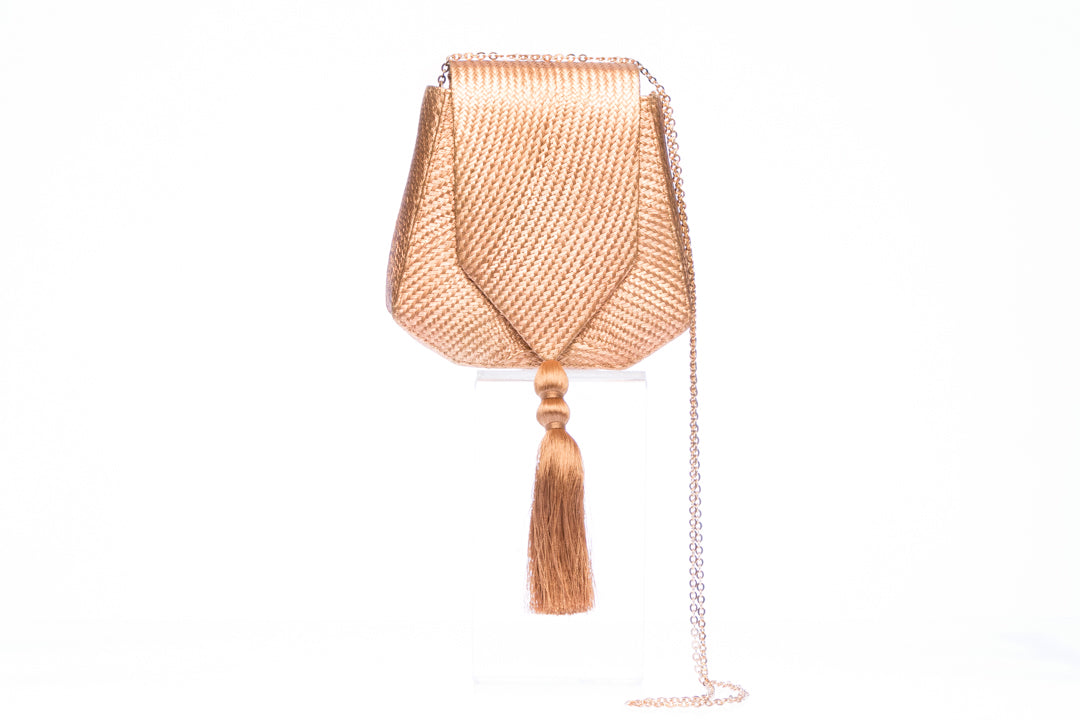 Bronze Glory Shoulder Bag with handwoven natural plant fibers, gold tassel, and brass chain strap. Sustainable and elegant design.