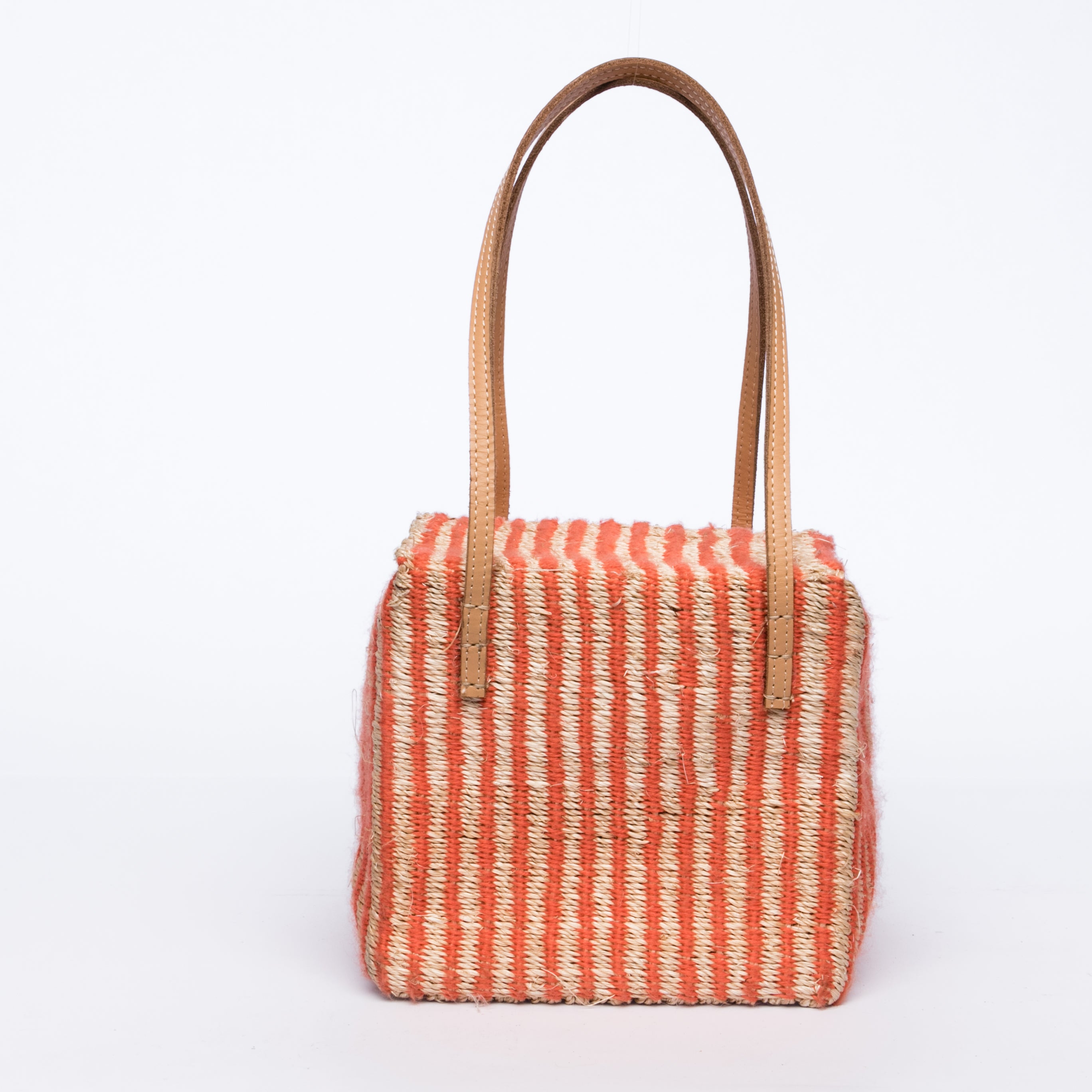 Pumpkin-colored Dolly Cube Handbag, handwoven with natural plant fibers and acrylic yarn, featuring sturdy cow leather handles and magnetic closures.