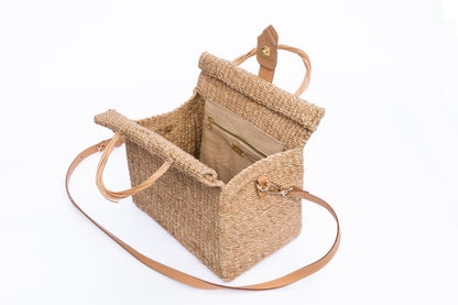 Dolly Cube Handbag with a unique cube shape, handwoven from natural plant fibers with cow leather handles, perfect for stylish city outings.