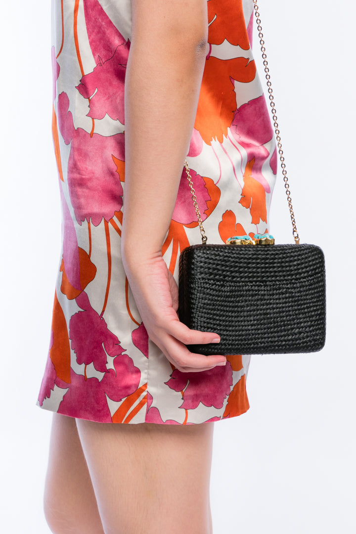 Iris Black Woven Clutch made from sustainable plant fibers, featuring a turquoise stone accent, brass drop-in chain strap, and fully lined interior for an eco-friendly and elegant look.