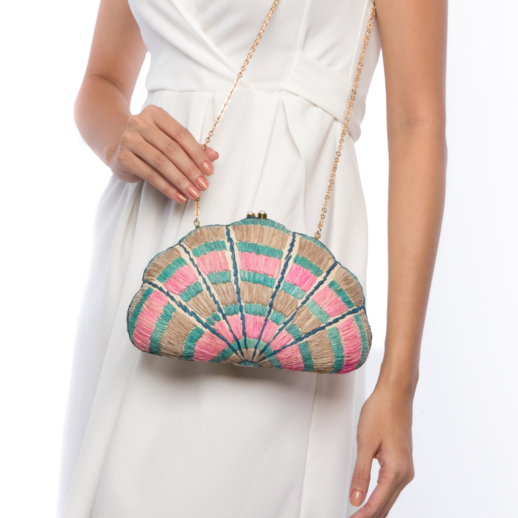Seashell Karuna Rainbow Clutch, hand-loomed raffia body with hand embroidery, adorned with freshwater pearls wrapped in brass, and a versatile brass drop-in chain strap.