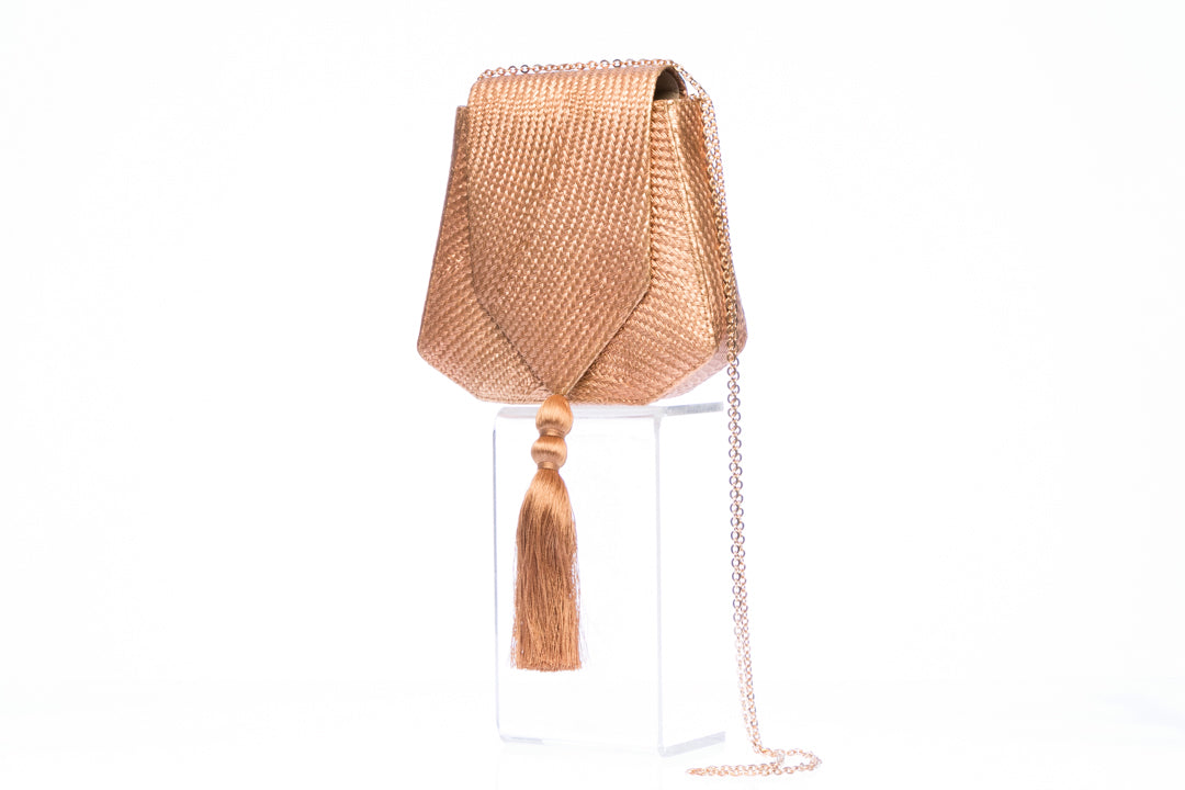 Bronze Glory Shoulder Bag with handwoven natural plant fibers, gold tassel, and brass chain strap. Sustainable and elegant design.