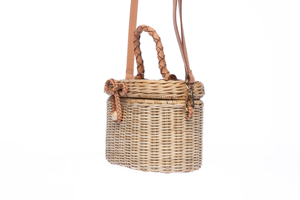 Camille Rattan Shoulder Bag made from handwoven rattan with adjustable leather strap and brass hardware. Eco-friendly and stylish design for any occasion.
