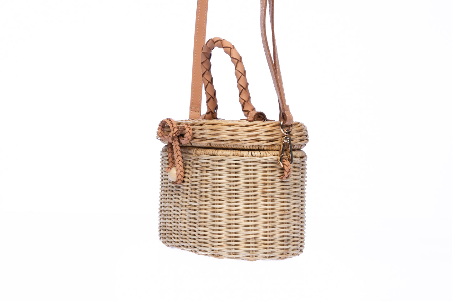 Camille Rattan Shoulder Bag made from handwoven rattan with adjustable leather strap and brass hardware. Eco-friendly and stylish design for any occasion.