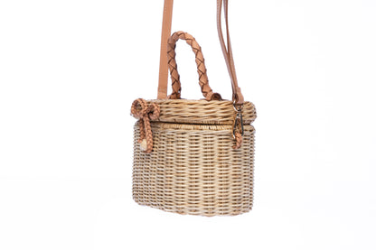 Camille Rattan Shoulder Bag made from handwoven rattan with adjustable leather strap and brass hardware. Eco-friendly and stylish design for any occasion.