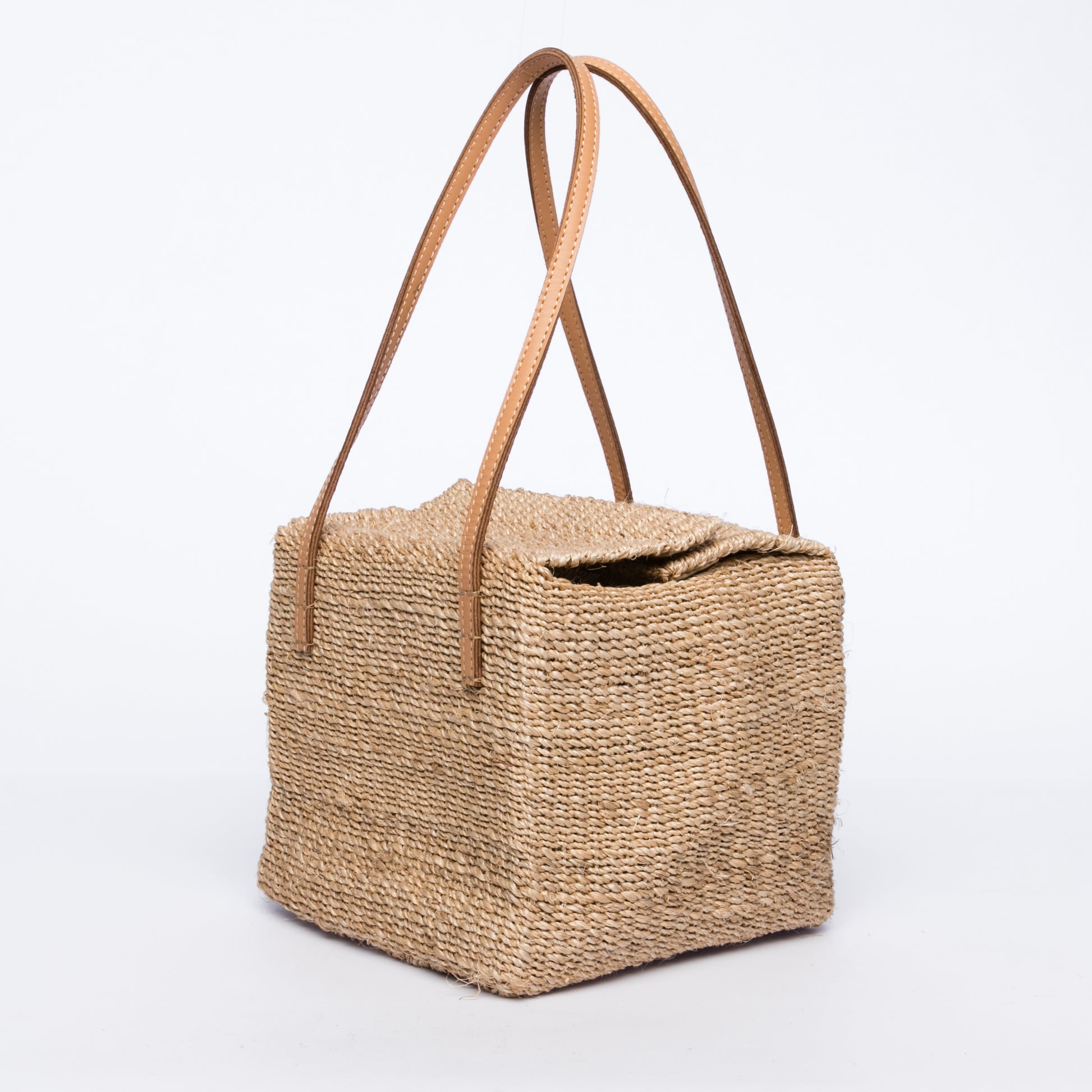 Dolly Cube Handbag with a unique cube shape, handwoven from natural plant fibers with cow leather handles, perfect for stylish city outings.