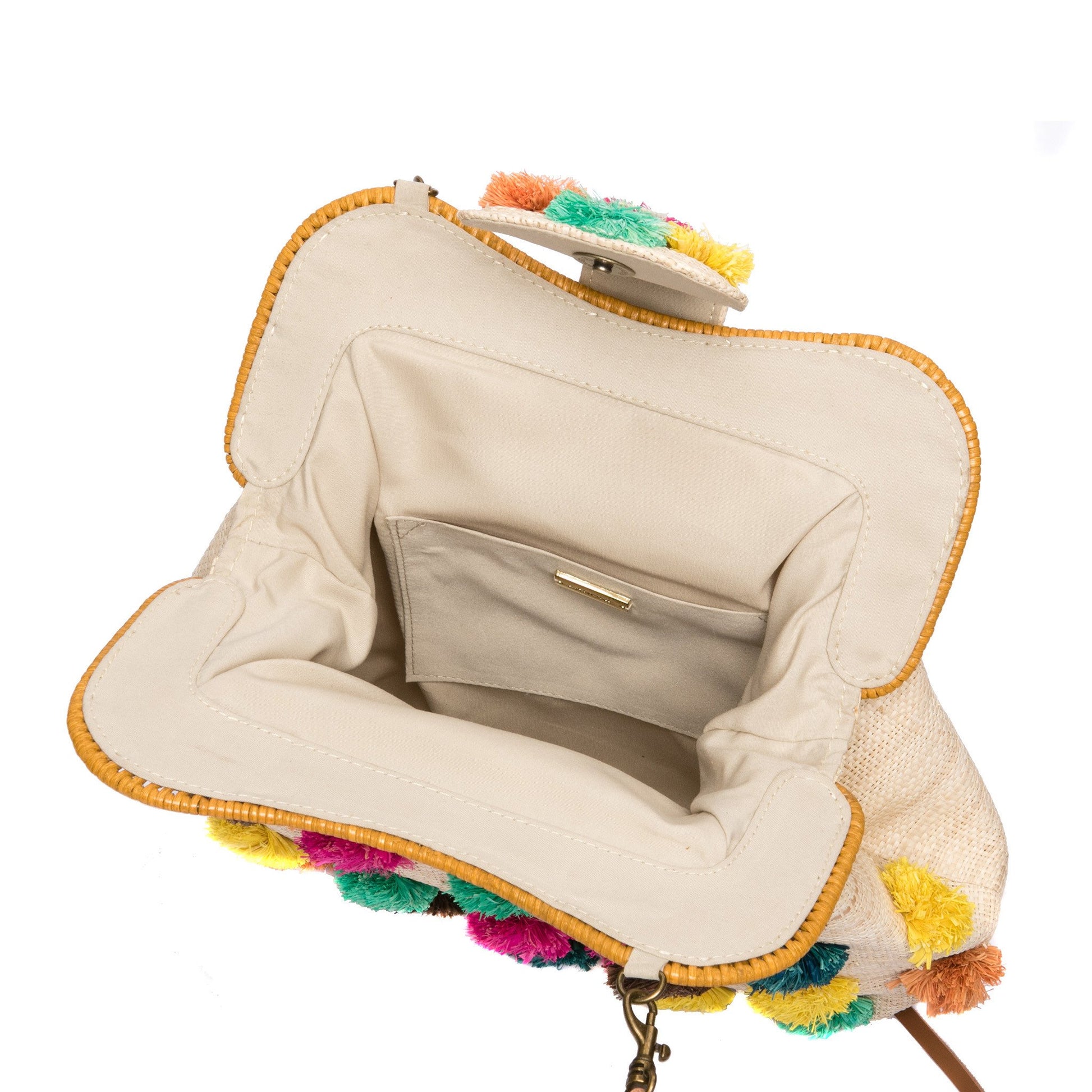 Forest Pompom Libby shoulder bag with handwoven raffia body, rattan frame, and fluffy raffia pompoms. Stylish and fun statement bag with leather strap.