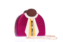 Load image into Gallery viewer, Gatsby Raspberry half-moon clutch made from handwoven natural plant fibers with a cracked sea shell bar and a brass chain strap, adding glamour and sophistication for any evening event.
