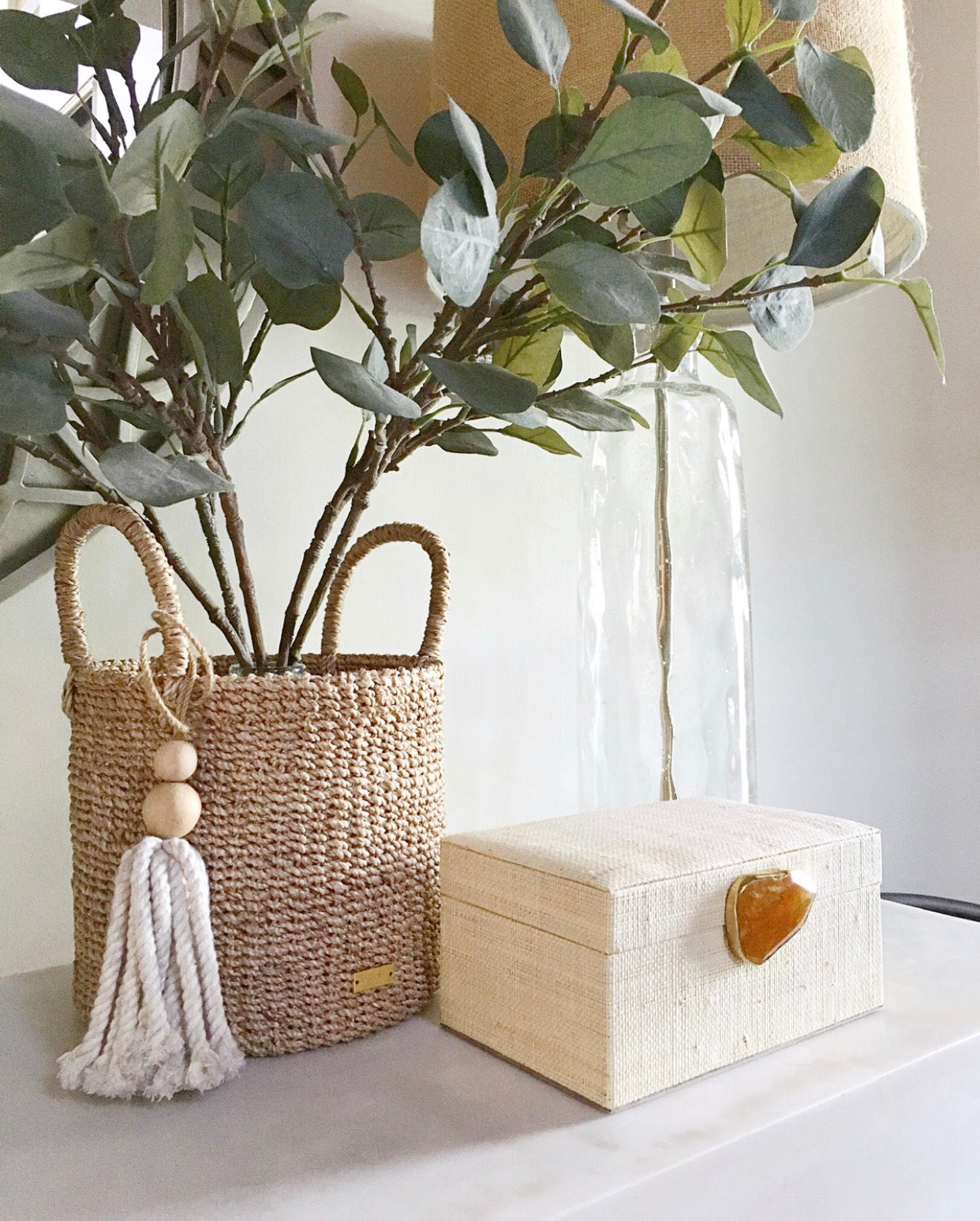 Karuna Raffia Jewelry Box crafted from handwoven natural plant fiber raffia with an agate stone accent capped in hand-tooled brass, perfect for stylish and eco-friendly jewelry storage.