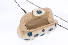 Load image into Gallery viewer, Seashell Signature raffia purse with hand-embroidered chevron design, featuring a removable brass chain strap for versatile wear as a shoulder bag or clutch.
