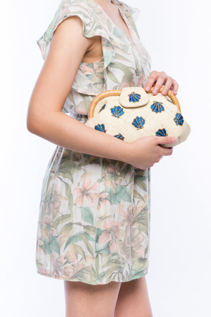 Seashell Signature raffia purse with hand-embroidered chevron design, featuring a removable leather strap for versatile wear as a shoulder bag or clutch.