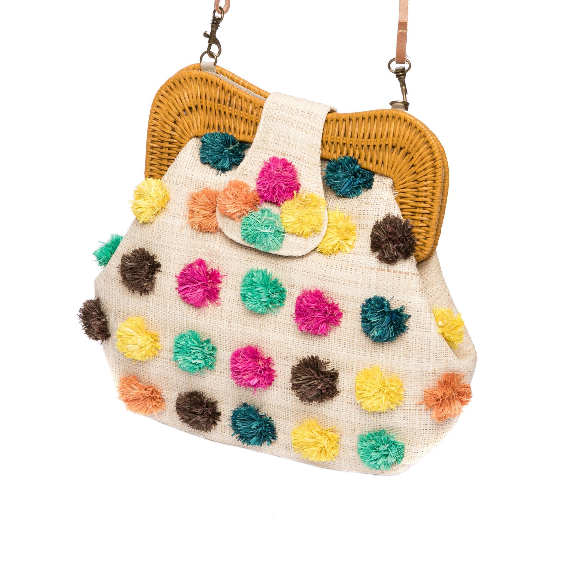 Forest Pompom Libby shoulder bag with handwoven raffia body, rattan frame, and fluffy raffia pompoms. Stylish and fun statement bag with leather strap.