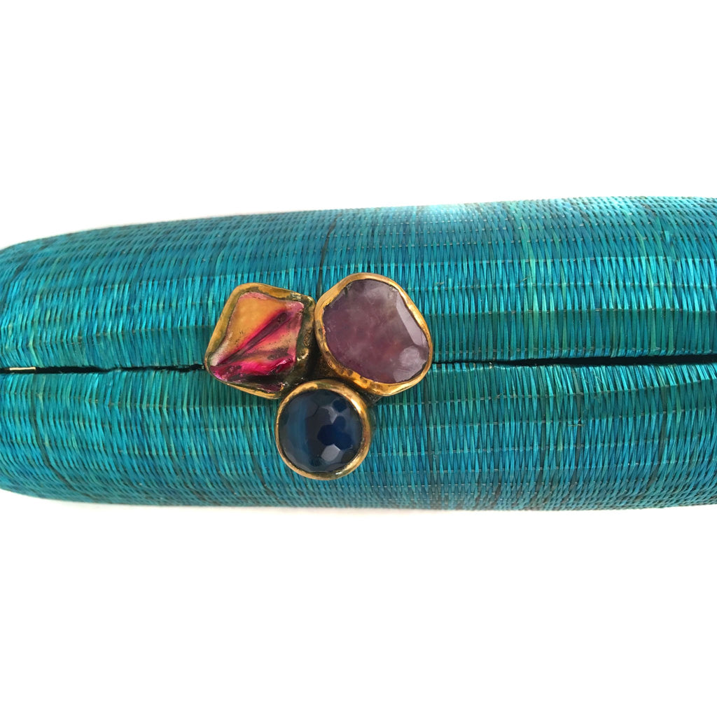 Turquoise Dream Oval Hard Case Purse made from handwoven Buri fiber, adorned with agate stones and brass accents, with a versatile drop-in brass chain for carrying as a clutch or shoulder bag.