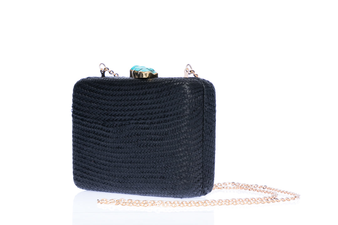 Iris Black Woven Clutch made from sustainable plant fibers, featuring a turquoise stone accent, brass drop-in chain strap, and fully lined interior for an eco-friendly and elegant look.