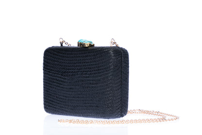 Iris Black Woven Clutch made from sustainable plant fibers, featuring a turquoise stone accent, brass drop-in chain strap, and fully lined interior for an eco-friendly and elegant look.