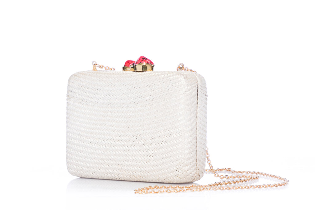 Iris White Woven Clutch made from sustainable plant fibers, featuring a bold red stone accent, brass drop-in chain strap, and fully lined interior for an eco-friendly yet elegant look.