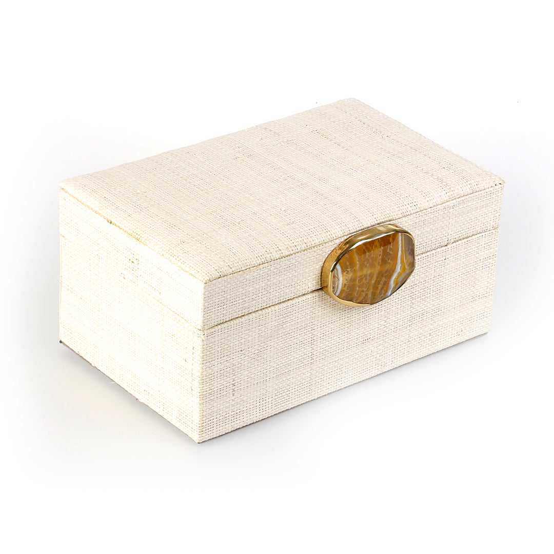 Karuna Raffia Jewelry Box crafted from handwoven natural plant fiber raffia with an agate stone accent capped in hand-tooled brass, perfect for stylish and eco-friendly jewelry storage.