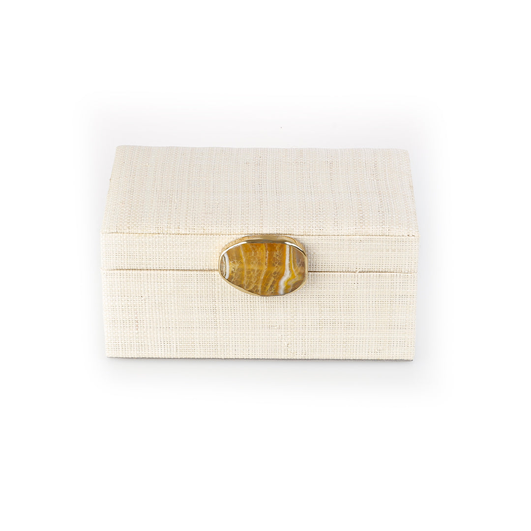Karuna Raffia Jewelry Box crafted from handwoven natural plant fiber raffia with an agate stone accent capped in hand-tooled brass, perfect for stylish and eco-friendly jewelry storage.