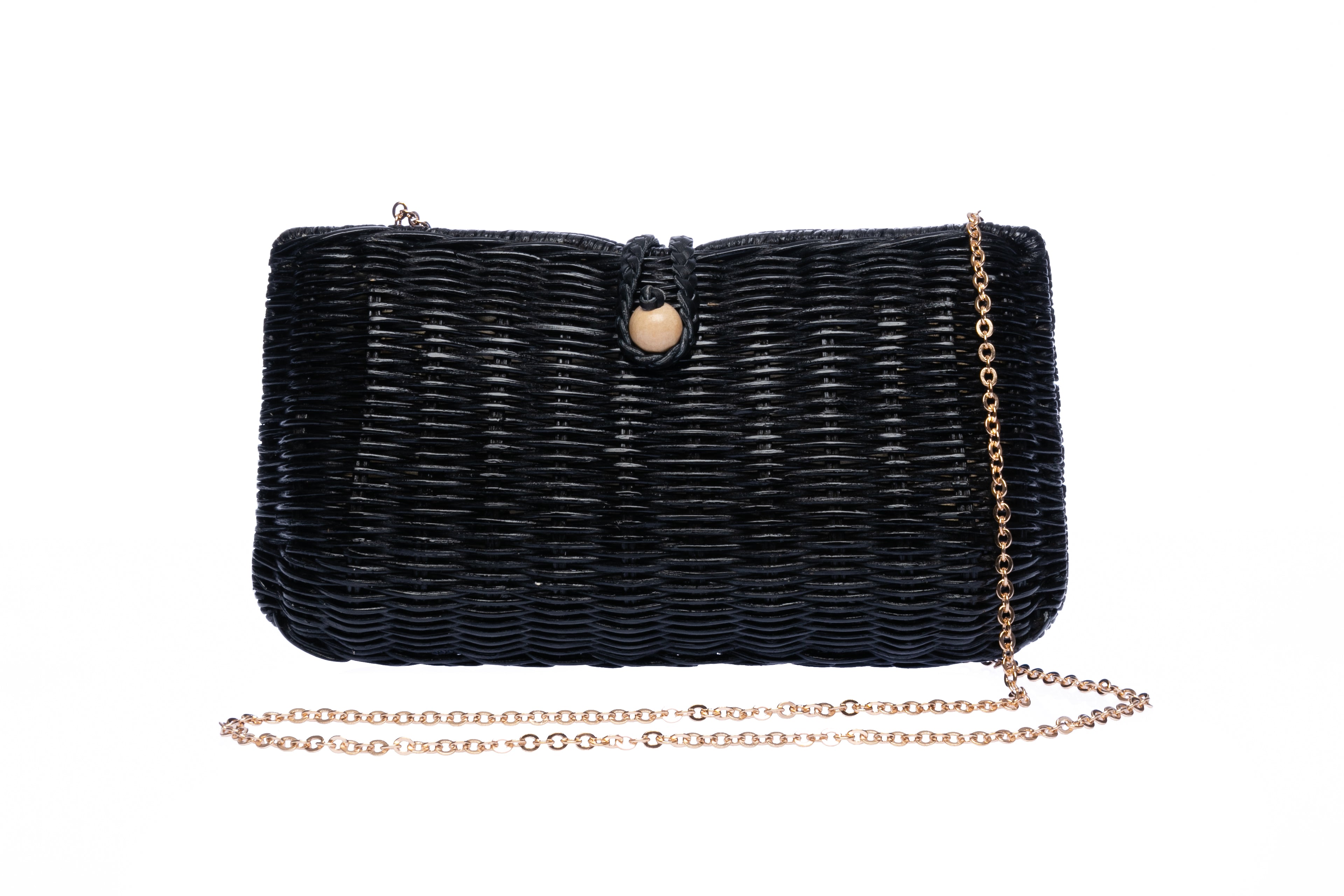 Myra Wicker Clutch Black handwoven from rattan with a brass chain strap and lined with linen and cotton, perfect for both day and night wear.