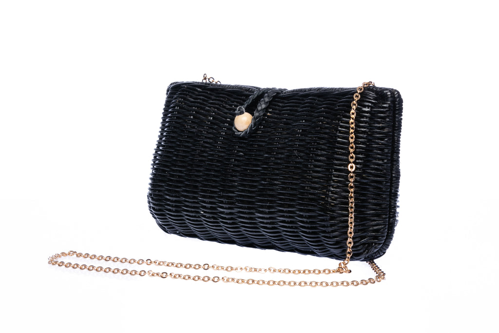 Myra Wicker Clutch Black handwoven from rattan with a brass chain strap and lined with linen and cotton, perfect for both day and night wear.