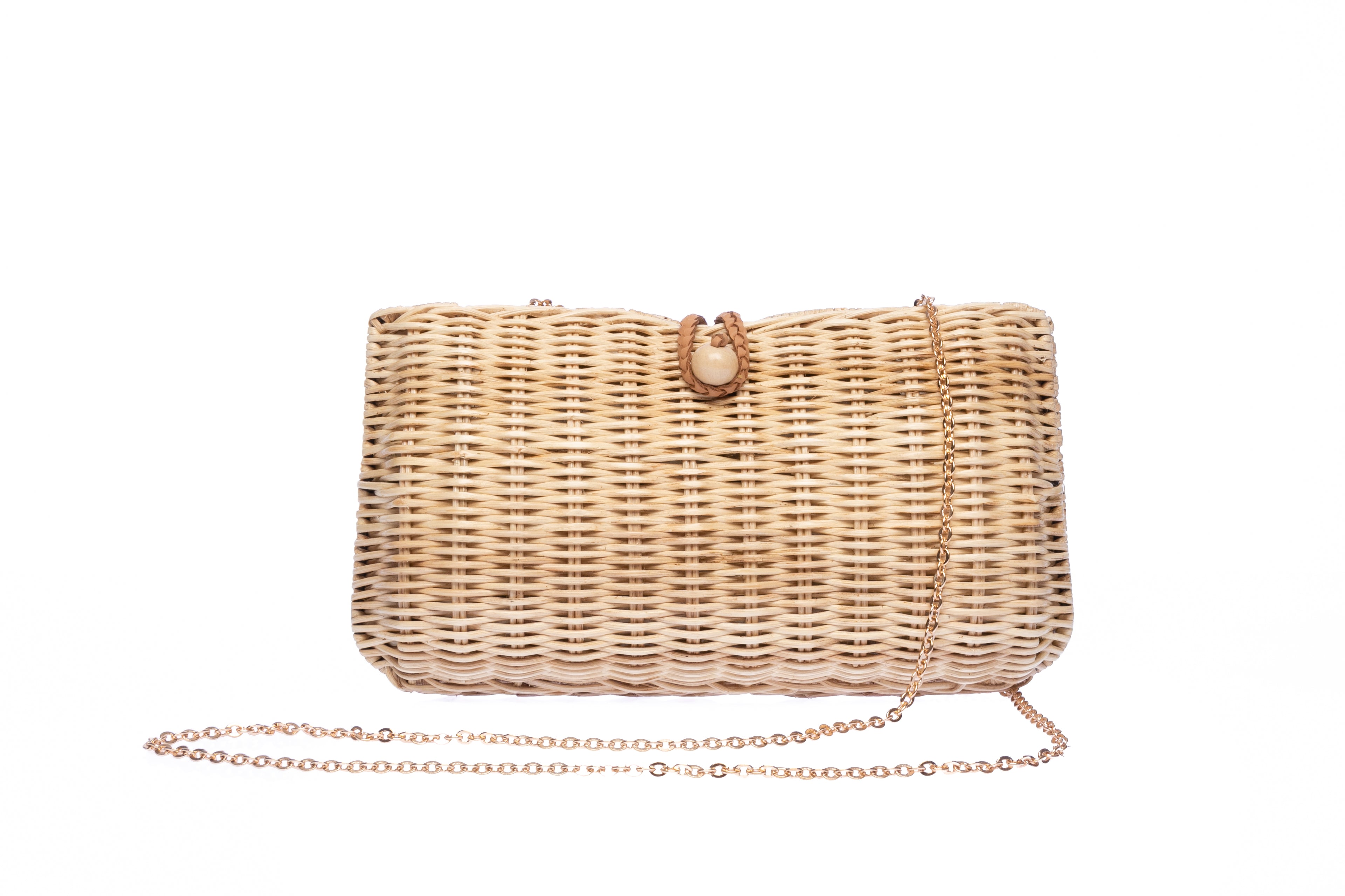 Myra Wicker Clutch Natural handwoven from rattan, featuring a brass chain strap and a soft linen-cotton lining, perfect for both day and night occasions.