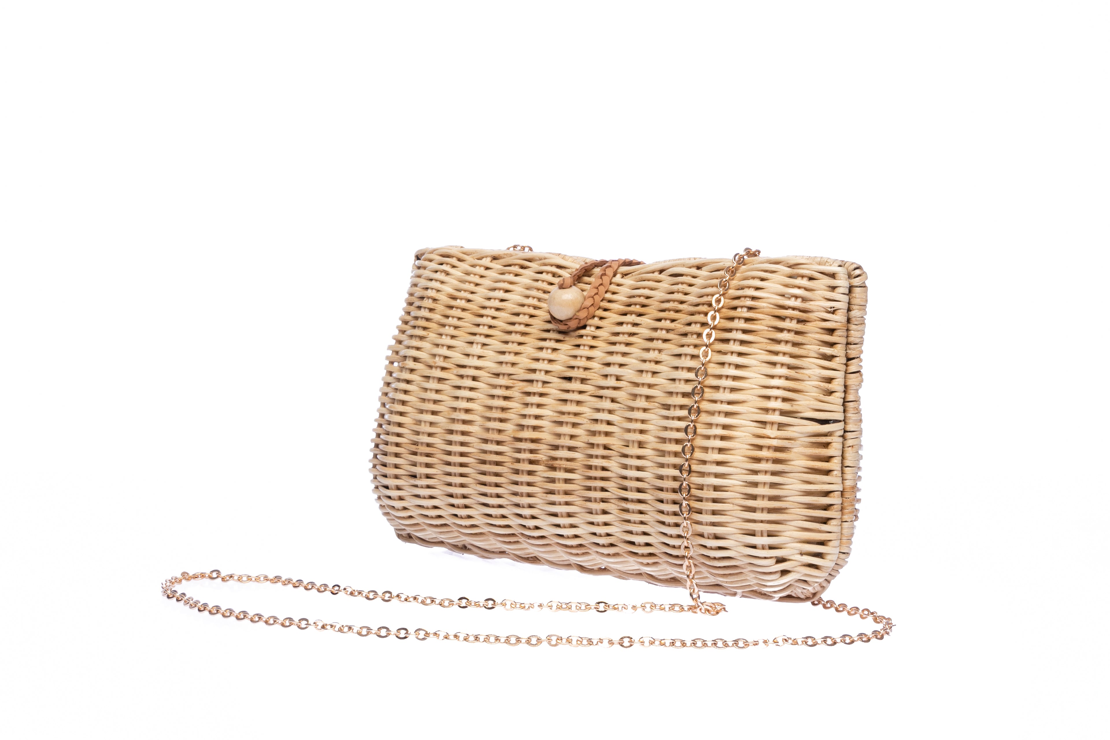 Myra Wicker Clutch Natural handwoven from rattan, featuring a brass chain strap and a soft linen-cotton lining, perfect for both day and night occasions.