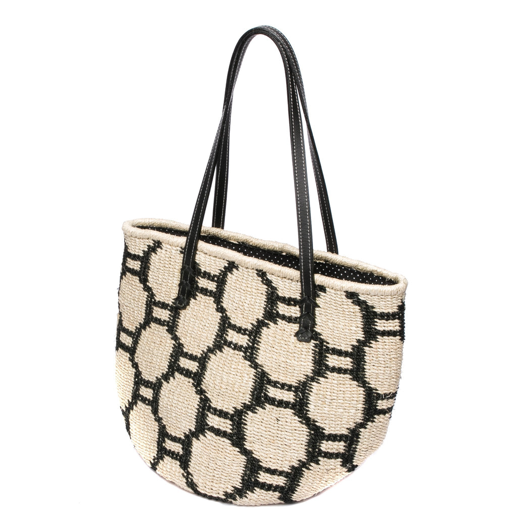 Beehive Tote Bag handwoven from natural plant fiber with leather handles and polka dot lining. Stylish and sustainable.