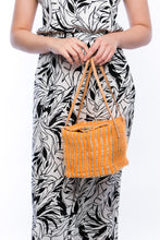 Load image into Gallery viewer, Pumpkin-colored Dolly Cube Handbag, handwoven with natural plant fibers and acrylic yarn, featuring sturdy cow leather handles and magnetic closures.
