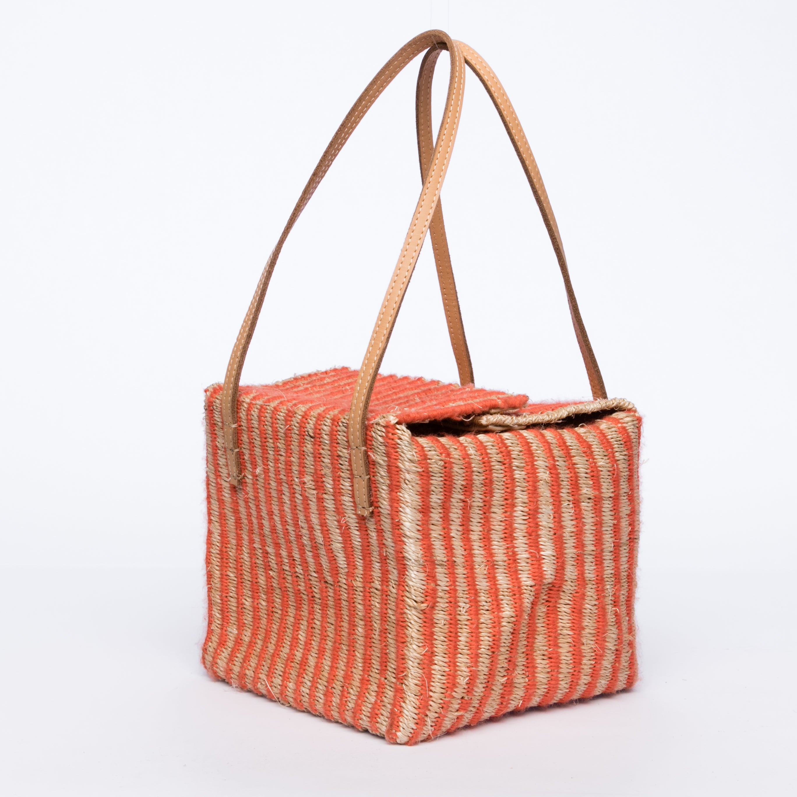 Pumpkin-colored Dolly Cube Handbag, handwoven with natural plant fibers and acrylic yarn, featuring sturdy cow leather handles and magnetic closures.