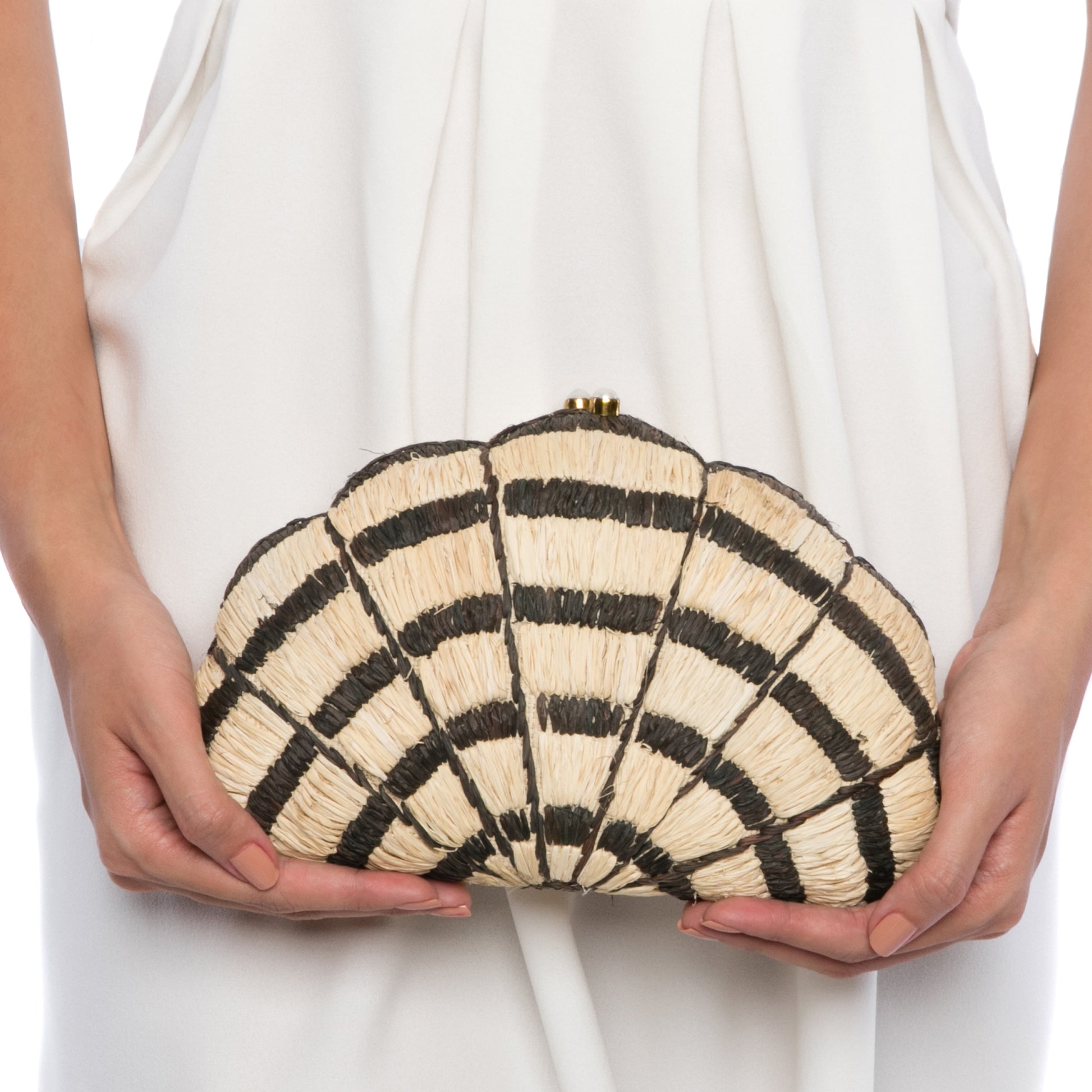 Seashell Karuna Clutch featuring hand-embroidered raffia fiber, freshwater pearls wrapped in brass, and a brass drop-in chain strap for versatility.