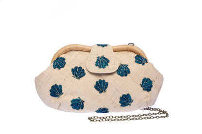 Seashell Signature raffia purse with hand-embroidered chevron design, featuring a removable brass chain strap for versatile wear as a shoulder bag or clutch.