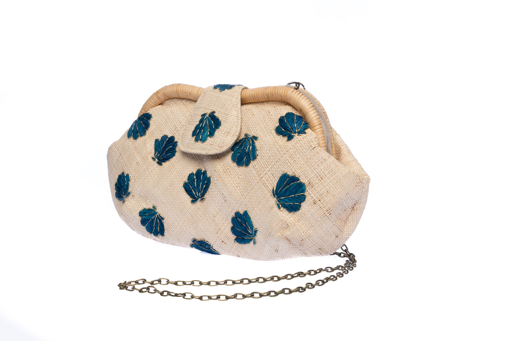 Seashell Signature raffia purse with hand-embroidered chevron design, featuring a removable brass chain for versatile wear as a shoulder bag or clutch.