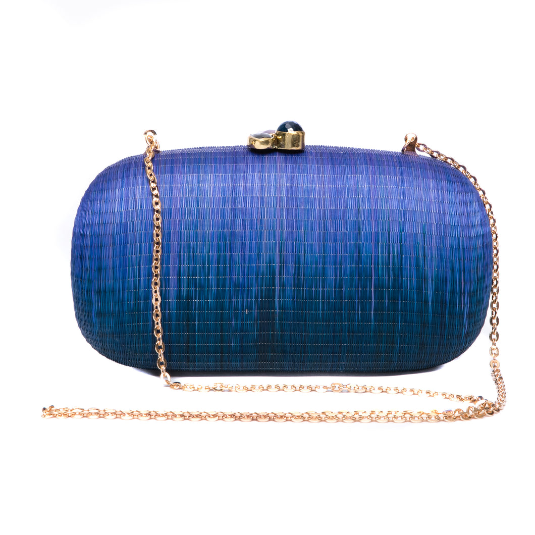 Still Waters Oval Hard Case Purse, handwoven from Buri plant fibers with agate stone accents and a brass chain strap for versatile carrying options.