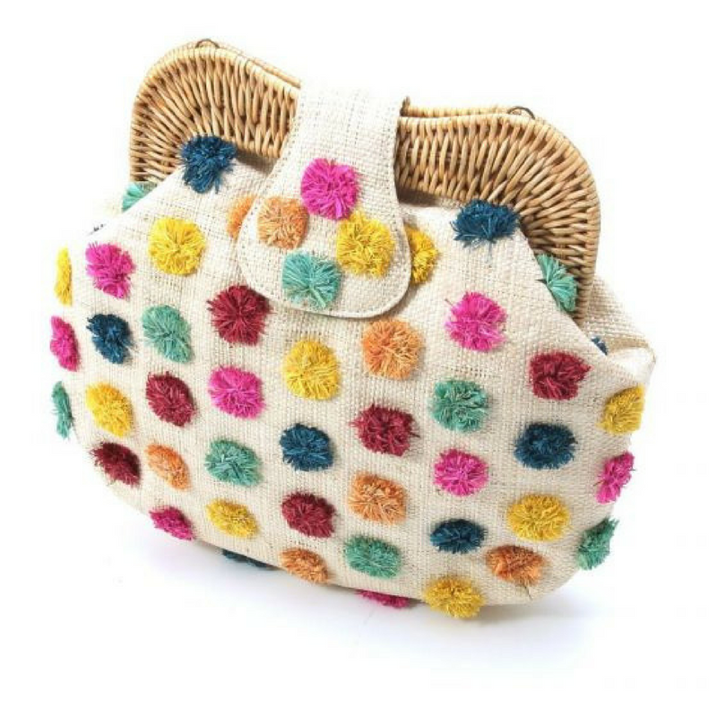 Forest Pompom Libby shoulder bag with handwoven raffia body, rattan frame, and fluffy raffia pompoms. Stylish and fun statement bag with leather strap.