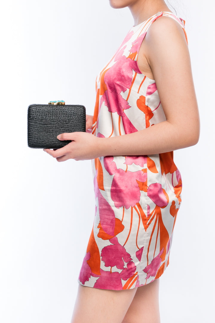 Iris Black Woven Clutch made from sustainable plant fibers, featuring a turquoise stone accent, brass drop-in chain strap, and fully lined interior for an eco-friendly and elegant look.